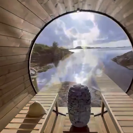 Inne i en fatbastu med utsikt över havet genom det runda fönstret